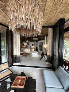 a living room with a couch and a chandelier at Happy Coco Monkey - Cozy Studio By Sp Villa in Koh Phangan