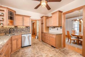 a kitchen with wooden cabinets and a dining room at 3 Bedroom Family Home - University of Oshkosh in Oshkosh