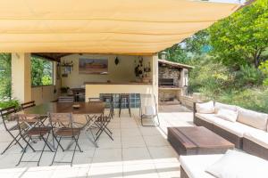a patio with a couch and a table and chairs at Gite Provençal in Grospierres