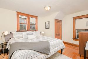 オシュコシュにあるCharacter Family Home - 3 bedroom 2 bathの大きなベッドと2つの窓がある寝室