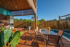 a patio with a table and chairs and a pool at Village das Estações in Marau