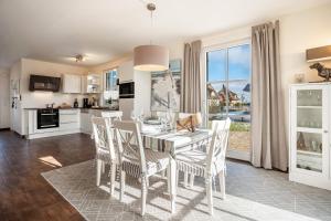 une cuisine et une salle à manger avec une table et des chaises dans l'établissement Ferienhaus Seeschwalbe 14, à Ummanz