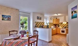 QuéménévenにあるLes Gîtes de kerouzailletのテーブルと椅子のあるキッチンとダイニングルーム