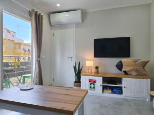 a living room with a flat screen tv on a wall at Casa Safia - Beach & Center 200m, AC, WiFi in Carvoeiro