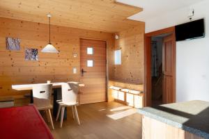 Cette chambre est dotée d'un mur en bois avec une table et des chaises. dans l'établissement Oberfahrerhof Jenesien, à Meltina