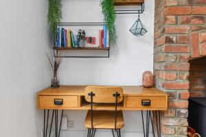 a wooden desk with a chair next to a wall at Convenient 3-Bed Near Bingham Station & Town Centre in Bingham +30 photos