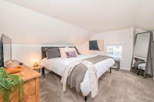 オシュコシュにあるDowntown 2 Bedroom Home - Officeの大きなベッドとテーブルと鏡のある寝室