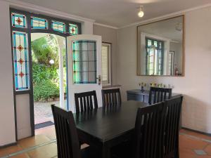 una sala da pranzo con tavolo, sedie e vetrate istoriate di Caribbean Estates Montego Bay 05 a Port Edward