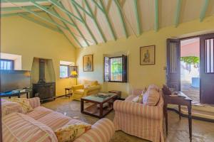 a living room with two couches and a tv at Cortijo Cantarranas - Tarifa in Tarifa
