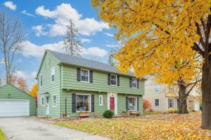 a green house with a red door at River Drive Retreat - Family Neighborhood sleeps 10 in Appleton