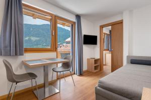 a bedroom with a bed and a desk and a window at Unterdornerhof Algund in Lagundo