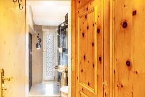 La salle de bains est pourvue de murs en bois et d'une porte en bois. dans l'établissement Ferienwohnung am Wehr, à Garmisch-Partenkirchen 31 autres photos