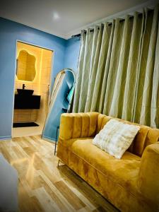 a living room with a yellow couch and a mirror at Y & N BnB in Alberton +24 photos