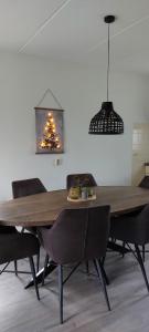 einen Esstisch mit Stühlen und einen Weihnachtsbaum in der Unterkunft Mooi Drenthe in Wezuperbrug