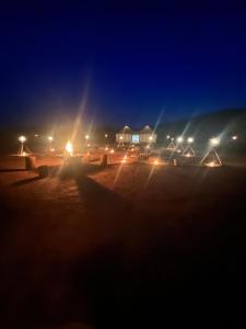 a group of tents on a beach at night at Across Sahara in Bou Nou
