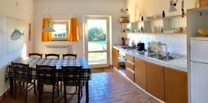 a kitchen with a table and chairs in a kitchen at La Casa Rossa in Marina di Bibbona