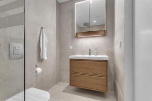 a bathroom with a sink and a toilet and a mirror at Castle Inn Apartments - Downtown Keflavík in Keflavík