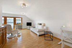 a living room with a white couch and a tv at Urlaub in der Sonnenstadt 72351 in Geislingen