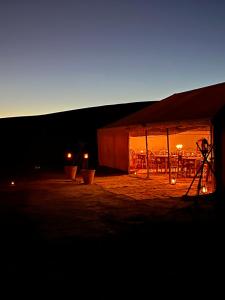 uma tenda com um tripé na frente à noite em Across Sahara em Bou Nou
