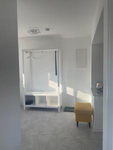 a white room with a mirror and a stool at Ferienwohnung Oleander in Dresden