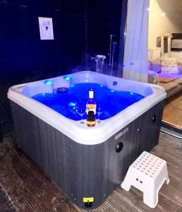 a blue bath tub with a bottle of whiskey in it at Family house with garden & jacuzzi & sauna near Amsterdam in Vijfhuizen