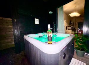 a bath tub with two wine glasses and a bottle at Family house with garden & jacuzzi & sauna near Amsterdam in Vijfhuizen