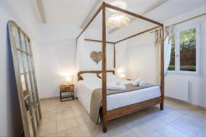 a bedroom with a canopy bed and a window at Domaine De Meyrol - Gite 3 in Eyguières