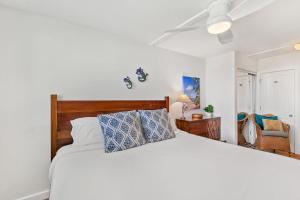 a bedroom with a white bed and a ceiling fan at Keawakapu 208 · KKP 208 Renovated Condo w AC Near Beach Shops in Wailea