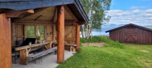 a wooden cabin with a bench and a barn at Buviken Nordre, Femund in Sømådalen
