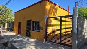 a yellow building with a gate in front of it at Departamentos Don Lorenzo Temporal in Junín