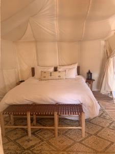 um quarto com uma cama numa tenda em Across Sahara em Bou Nou