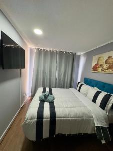 um quarto com uma cama com um ursinho de pelúcia em Teatinos Departamentos STGO em Santiago
