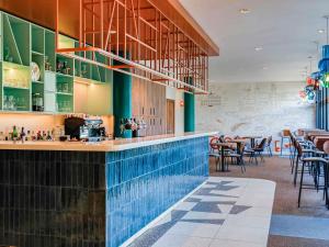 ルクセンブルクにあるIbis Luxembourg Airportのスイミングプール付きのレストラン、バー