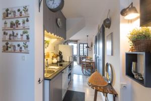 LanasにあるMaisonnette de charme Bord Ardècheのシンクと壁に時計が付いたキッチン