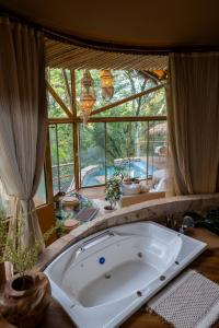 a large tub in a room with a large window at Satori Zen Club in Itauguá
