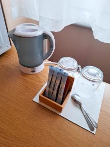 a table with a cup and a box of books and a coffee mug at LUNA Marijampole in Marijampolė