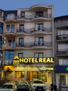 a hotel with cars parked in front of it at Hotel Real in Pristina