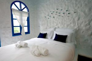 Un dormitorio con una gran cama blanca con ventana. en Sweett Lemon Home, en Patong Beach