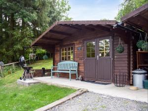 a small wooden shed with a bench in a yard at Moonlight View - Uk35187 in Newtown