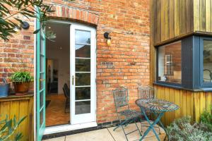 un patio avec une table et une chaise à côté d'un bâtiment en briques dans l'établissement Convenient 3-Bed Near Bingham Station & Town Centre, à Bingham