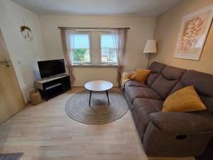 a living room with a couch and a table at Ferienhäuschen in Dickesbach in Dickesbach