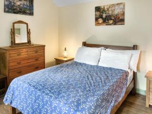 a bedroom with a bed and a dresser and a mirror at Barnside Cottage - Uk50574 in Hayton