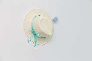 a white hat with a blue ribbon on a wall at Casa vacanze “Genna ‘e su Monte” in Baunei