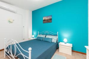 a blue bedroom with a bed and a blue wall at Casa vacanze “Genna ‘e su Monte” in Baunei