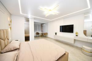 een slaapkamer met een groot bed en een flatscreen-tv bij VS Gold Apartament in Galaţi