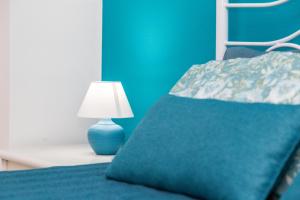 a blue bed with a blue pillow and a lamp at Casa vacanze “Genna ‘e su Monte” in Baunei