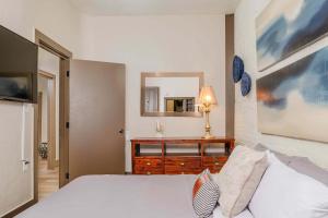 オシュコシュにあるLarge Luxury Downtown Loft - Walk to Everything Free Parkingのベッドと鏡付きのドレッサーのある寝室