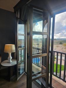 a room with glass doors and a lamp on a table at RL Ciudad de Úbeda in Úbeda