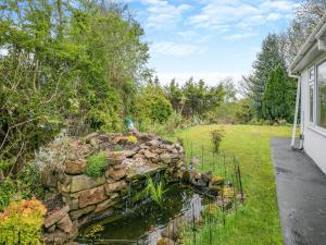 eine Steinmauer in einem Garten neben einem Haus in der Unterkunft Forest View Cottage in Nottingham