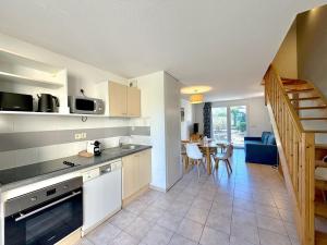 a kitchen and living room with a table and a staircase at Les Deux Terrasses, 6 pers Piscine à Calvisson in Calvisson